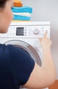 Housekeeper turning on washing machine Royalty Free Stock Photo