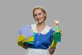 Housekeeper in uniform holding cleaning supplies.