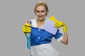 Housekeeper in uniform holding cleaning supplies.