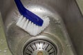 Housekeeper washes dirty washbasin with brush