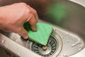 Housekeeper washes dirty washbasin with washcloth