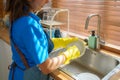 Housekeeper Washing Dishes in the Kitchen Sink