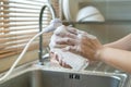 Housekeeper washing a dishes.