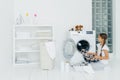 Housekeeping, children and domestic chores concept. Happy kid unloads washing machine, puts clean washed clothes in basin, curious