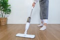 Housekeeping concept, Housemaid use mop to mopping and cleaning dust on the floor in living room Royalty Free Stock Photo