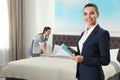 Housekeeping manager with tablet checking maid work in hotel room Royalty Free Stock Photo