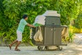 Housekeeping worker in uniform pushing the cart with cleaning tools Royalty Free Stock Photo