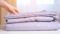 Housemaid puts clean folded knitwear clothes on white table Royalty Free Stock Photo