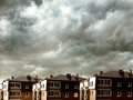 Houses against dark clouds