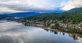 houses along a large lake surrounded by trees and mountains on the edge. Vancouver, BC, Canada. Royalty Free Stock Photo