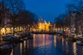 Traditional old buildings and boats at night in Amsterdam Royalty Free Stock Photo