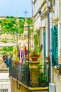Houses with balconies overlooking a narrow street in Modica, Sicily, Italy Royalty Free Stock Photo