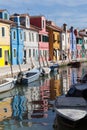 Houses of Burano and reflection in the water. Waterways with traditional boats and colorful facade Royalty Free Stock Photo