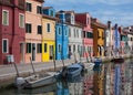 Houses of Burano and reflection in the water. Waterways with traditional boats and colorful facade Royalty Free Stock Photo