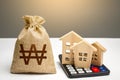 Houses on a calculator and south korean won money bag. Buying and selling. Real estate valuation. Building maintenance. Mortgage.