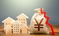 Houses and chinese yuan or japanese yen money bag with down arrow. Falling of real estate market prices. Reducing maintaining cost Royalty Free Stock Photo