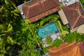 Houses with colorful shingle roofs and pool with swimming woman between palm trees Royalty Free Stock Photo