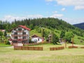 Houses in countryside landscape of grassy field and forest at Beskid Mountains range on Bialy Krzyz in POLAND Royalty Free Stock Photo