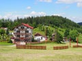 Houses in countryside landscape of grassy field and forest at Beskid Mountains range on Bialy Krzyz in POLAND Royalty Free Stock Photo