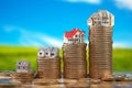 Houses of different size with on stacks of coins. Property, mortgage and real estate investment concept