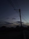 Houses and electrical wires against evening cloudy sky Royalty Free Stock Photo