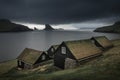 Houses with grass roofs in front of Drangarnier rock formations on Vagar, Faroe Islands