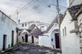 A street full of a typical white cottages in alberobello with nice pointed roofs