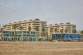 Houses on a large sandy beach with large glass windows