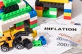 Houses made of toy blocks, electrical diagrams of house, euro banknotes with inscription inflation. High prices building or Royalty Free Stock Photo