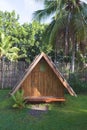 Houses made of wood. Bungalow with a roof made of palm leaves against the backdrop of a fence of bamboo and palm trees. Royalty Free Stock Photo