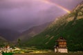 Houses in a mountain village with a rainbow background