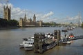 Houses of Parliament, local pier for boats, Big Ben, and Thames River. Royalty Free Stock Photo