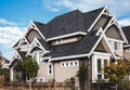 Houses with shingle roof against blue sky. Edge of roof shingles on top of the houses dark asphalt tiles on the roof