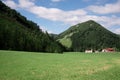 Houses in a small village with green mountains under blue cloudy sky on a sunny day Royalty Free Stock Photo