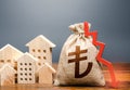 Houses and turkish lira money bag with down arrow. Falling of real estate market prices. Reducing maintaining cost, energy Royalty Free Stock Photo