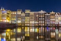 Houses on the Warmou straat reflected in the water of Damrak Royalty Free Stock Photo