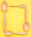 Houseware: wooden kitchen spoons, isolated on yellow background top view. Zero waste, eco friendly concept. Flat lay frame