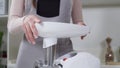 Housewife in apron assembles meat grinder head for providing quality mince frommeat. Electric mincer machine for minced
