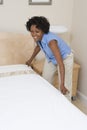 Housewife Arranging Bed At Home