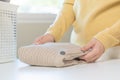 Housewife, asian young woman hand in many folding freshly shirts, sweaters or dress on desk, table after washing clean clothes and Royalty Free Stock Photo