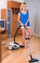 Housewife in casual hoovering at home