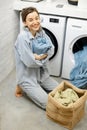 Housewife with clean towels in the laundry room at home