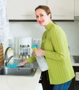 Housewife cleaning furniture in kitchen Royalty Free Stock Photo