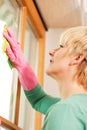 Housewife cleaning her windows in rubber gloves Royalty Free Stock Photo