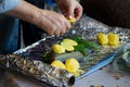 Woman is cooking salmon fish with with potatoes and and dill in foil. Royalty Free Stock Photo