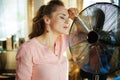 Housewife enjoying fresh air in front of working fan Royalty Free Stock Photo