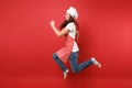 Housewife female chef cook or baker in striped apron white t-shirt, toque chefs hat isolated on red wall background