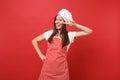 Housewife female chef cook or baker in striped apron white t-shirt toque chefs hat isolated on red wall background Royalty Free Stock Photo