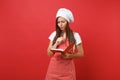Housewife female chef cook or baker in striped apron white t-shirt toque chefs hat isolated on red wall background Royalty Free Stock Photo