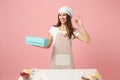 Housewife female chef cook confectioner or baker in apron white t-shirt, toque chefs hat packaging cake cupcake at table